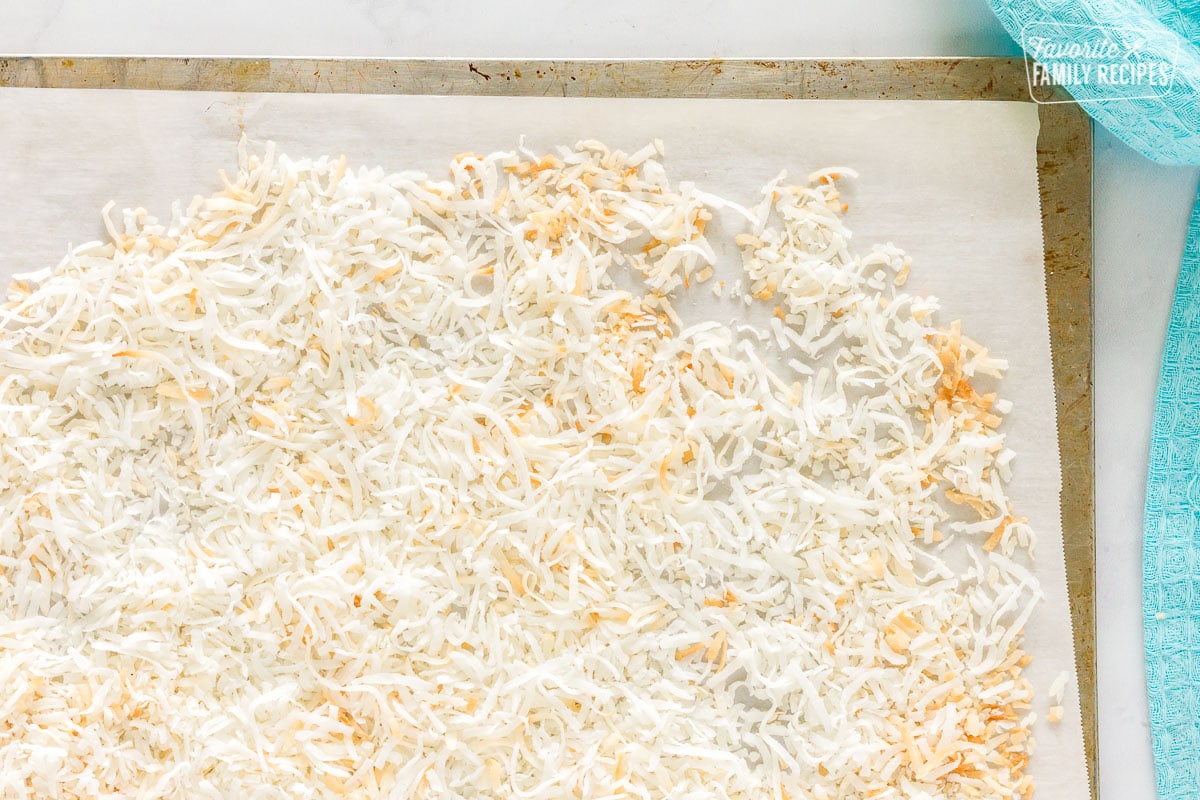 Lightly toasted coconut on a sheet pan for coconut cream cake.