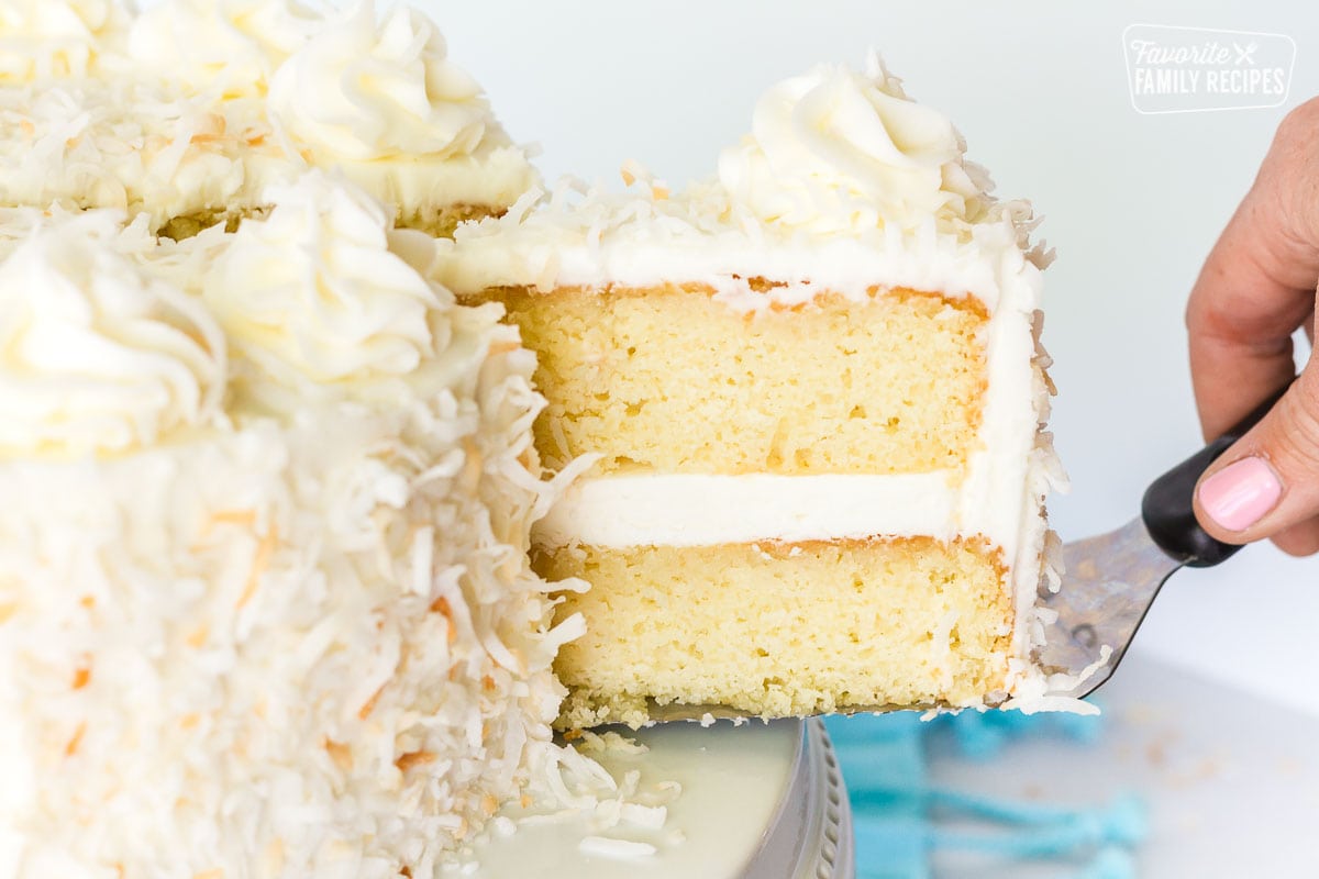 Slice of coconut cream cake with coconut frosting.