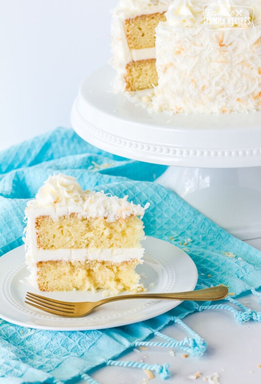 Plate of sliced coconut cream cake with coconut frosting.