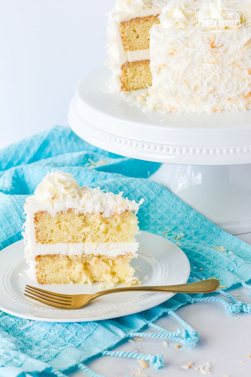 Plate of sliced coconut cream cake with coconut frosting.