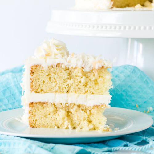 Close up of coconut cream cake with coconut frosting slice.