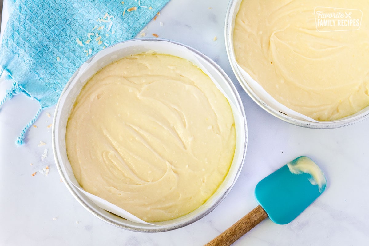 Two round cake pans with coconut cream cake batter.
