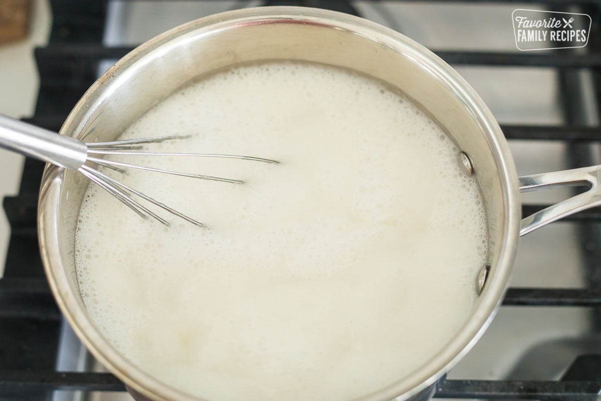 Coconut milk, sugar, corn syrup, and Greek yogurt mixed together in a saucepan