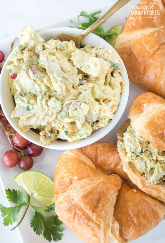Curry chicken salad in a bowl next to croissants