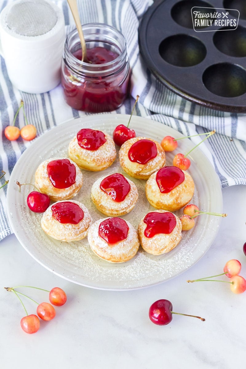 Danish Aebleskiver on a serving plate with cherry preserves.