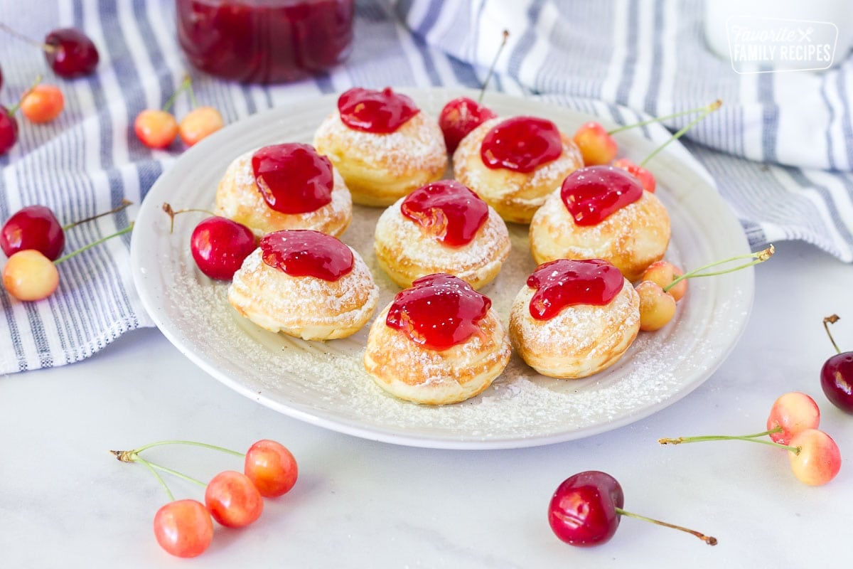 Plate of Danish Aebleskiver with powdered sugar and jam.