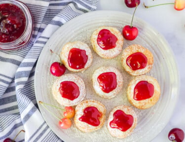 Top view of Danish Aebleskiver with cherries and a pan.