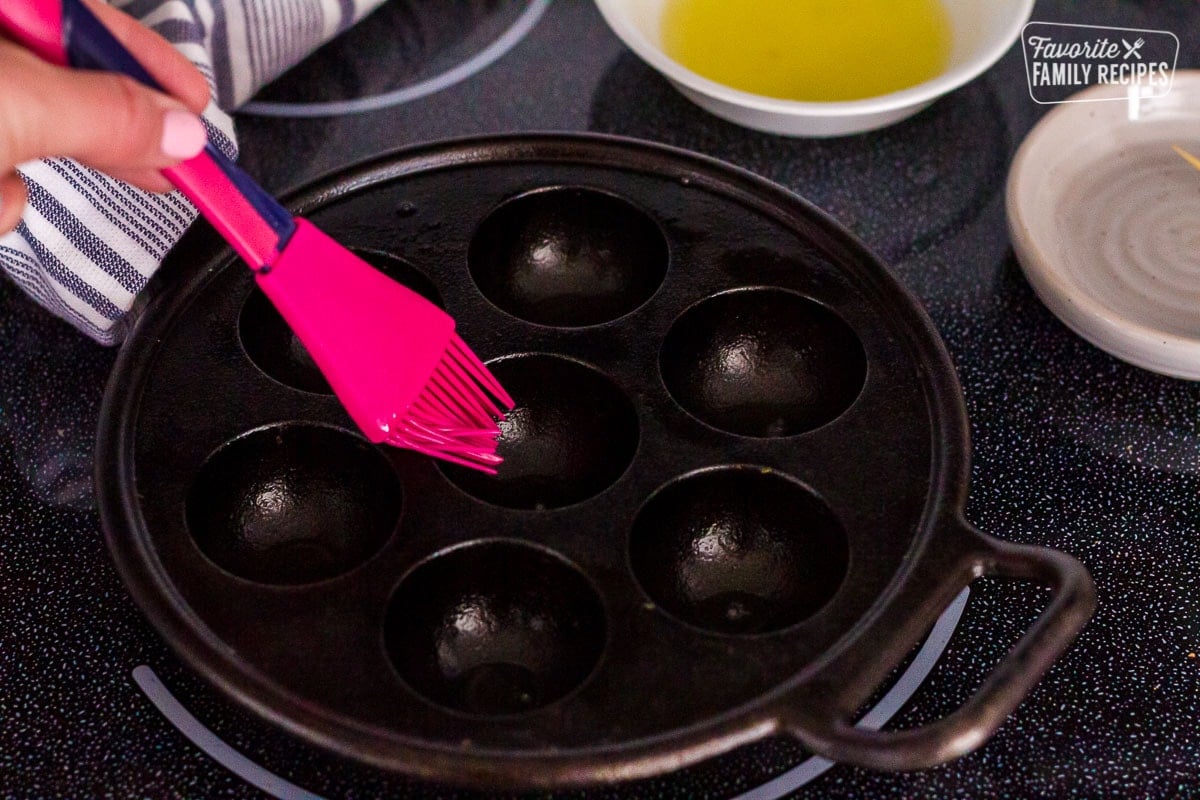 Danish Aebleskiver pan buttered with a brush.