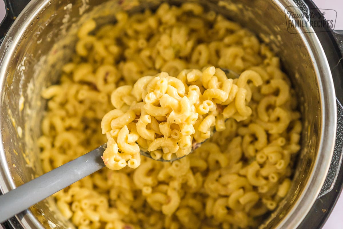 A spoonful of mac and cheese scooped out of an instant pot.