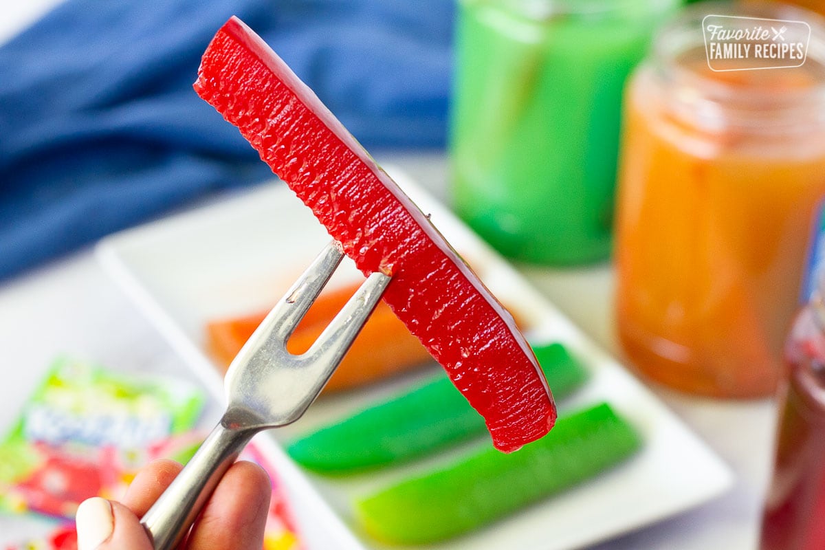 Fork piercing a red Kool Aid Pickle.