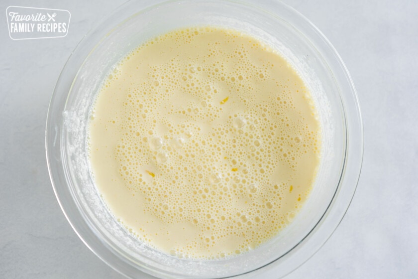 Ricotta, lemon juice, lemon zest, eggs, milk, and almond extract mixed together in a bowl