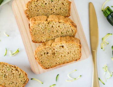 Wooden board with sliced Mom's Zucchini Bread.