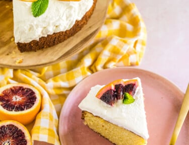 A slice of olive oil cake on a plate with slices of blood oranges