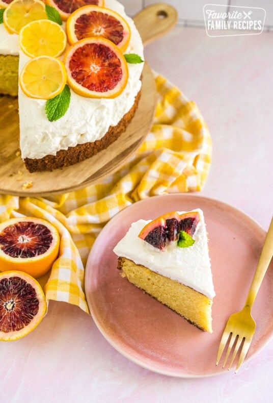 A slice of olive oil cake on a plate with slices of blood oranges