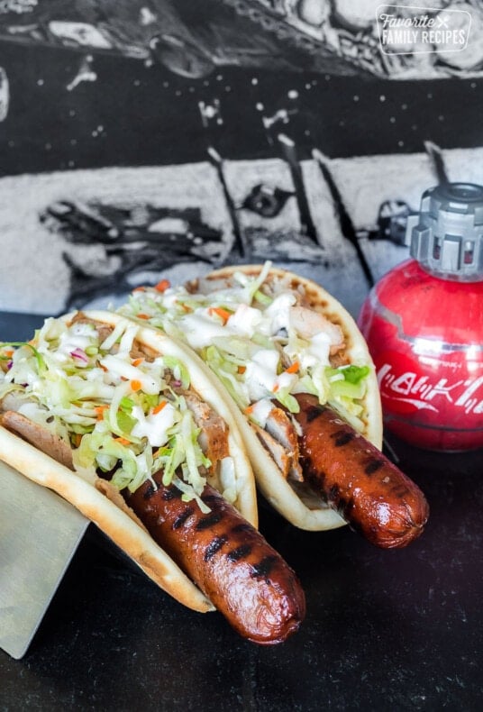 Two Ronto Wraps topped with slaw and next to a bowl of peppercorn dressing