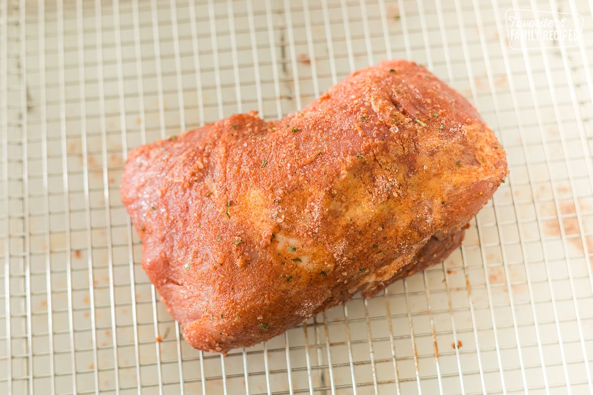 Uncooked pork roast on a roasting rack