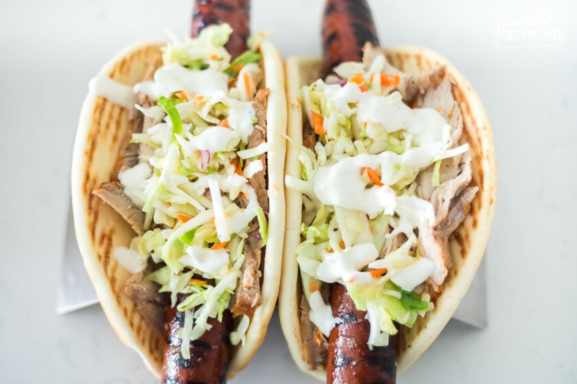 Fully assembled Ronto wraps with smoked sausage, pork, slaw, and dressing