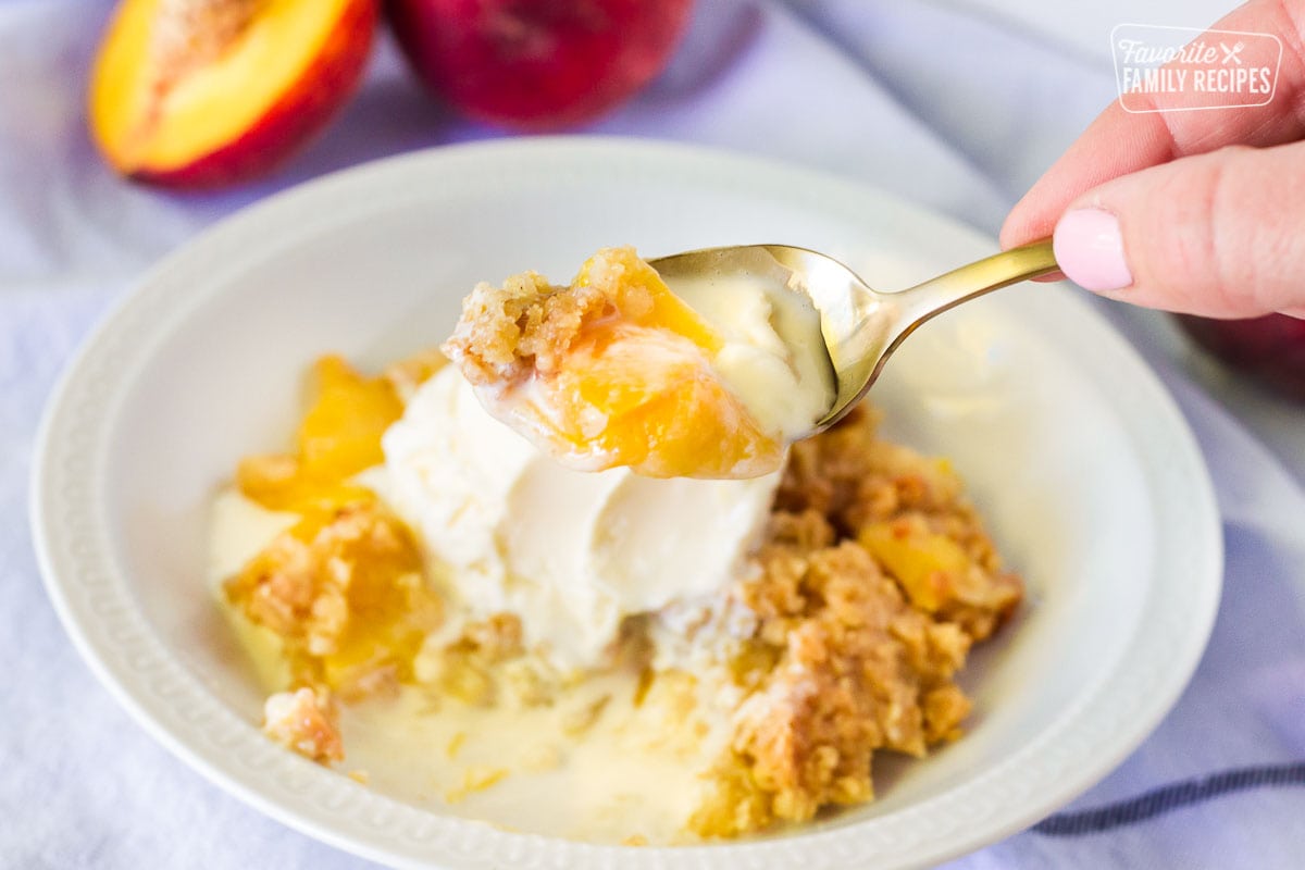 Spoon scooping out bite of Summer Peach Crisp.