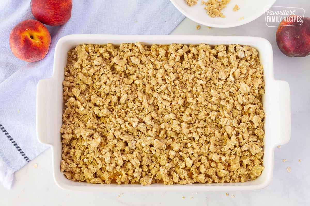 Unbaked Summer Peach Crisp in a 9x13 pan.