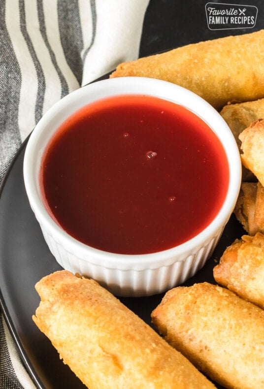 A close up of a serving bowl of sweet and sour sauce