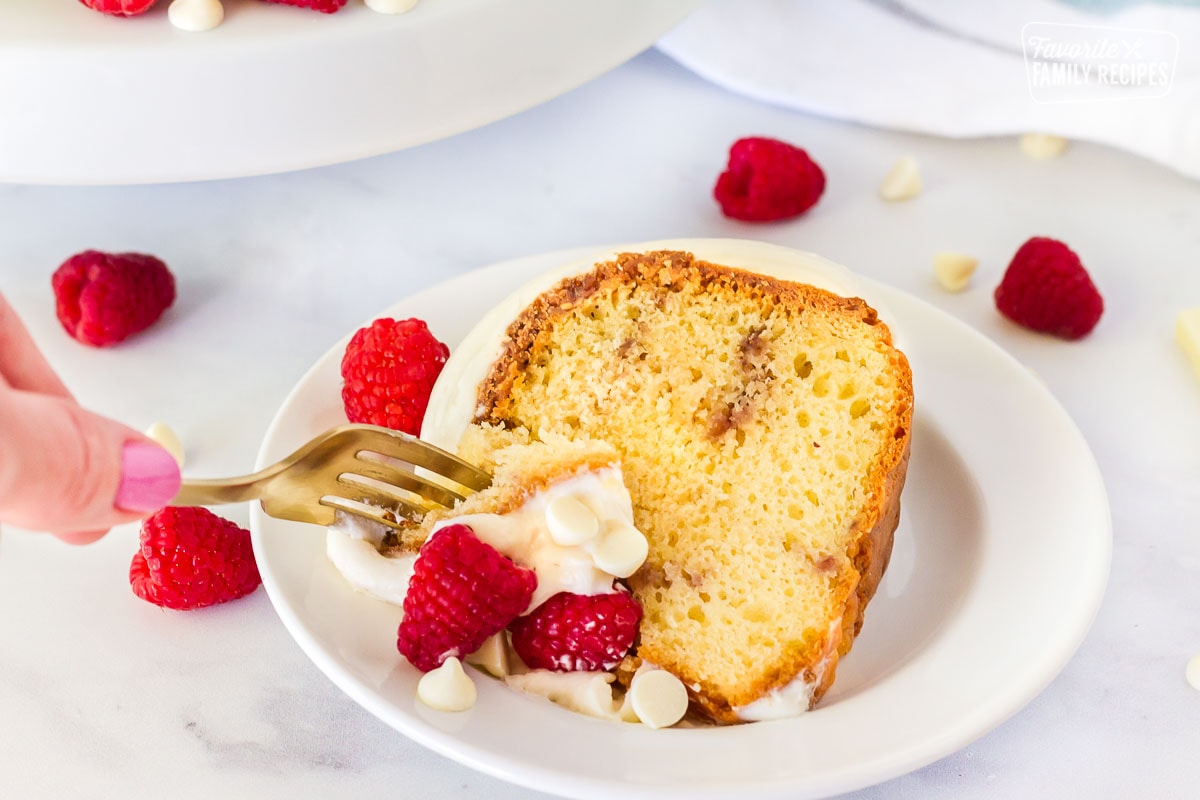 Fork cutting into White Chocolate Raspberry Cake.