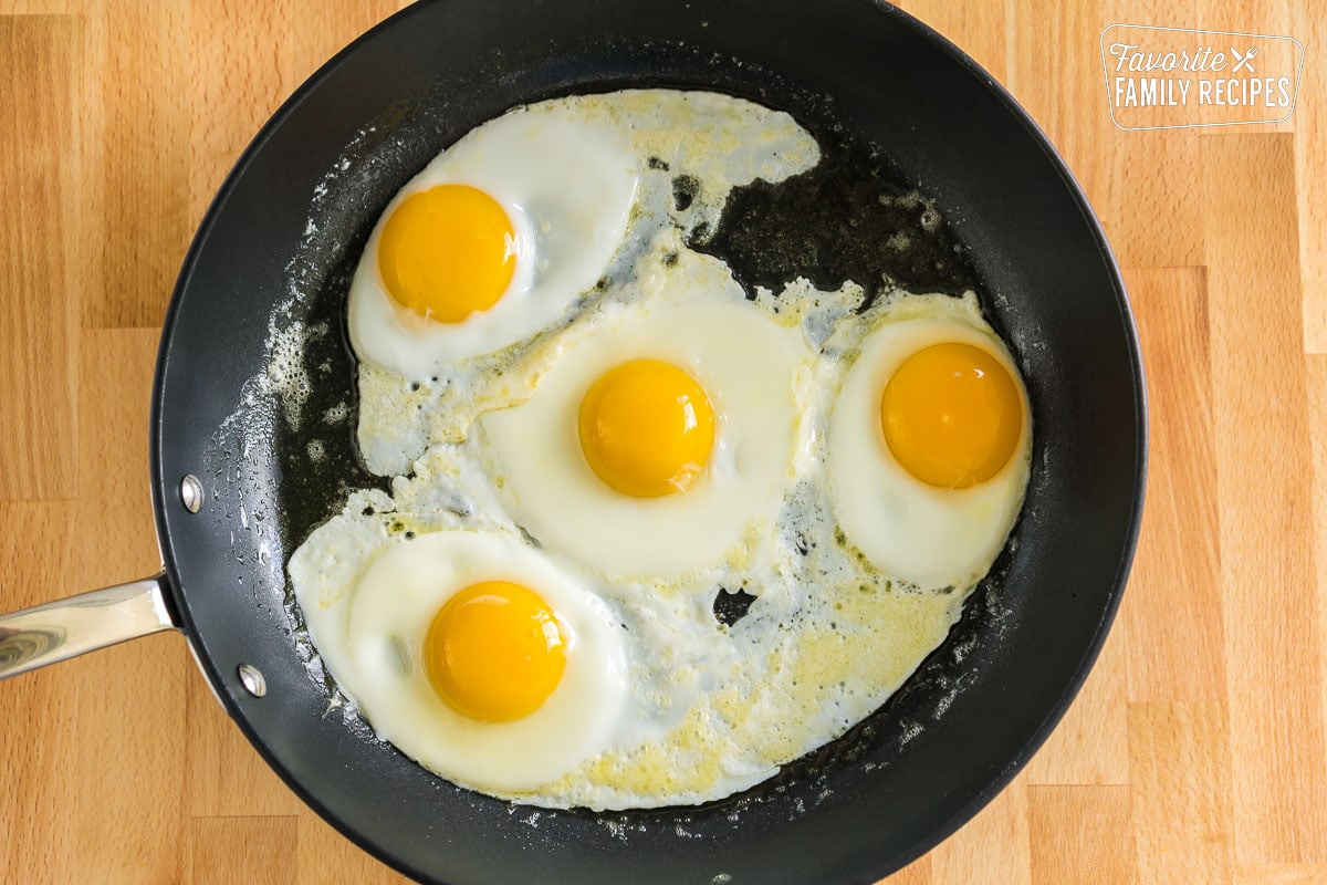 Four eggs cracked into a skillet