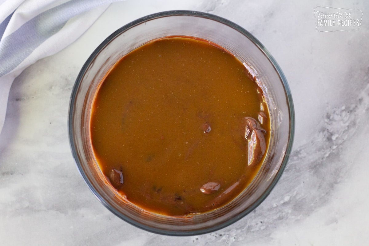 Caramel sauce layer in a glass trifle dish to make chocolate trifle.
