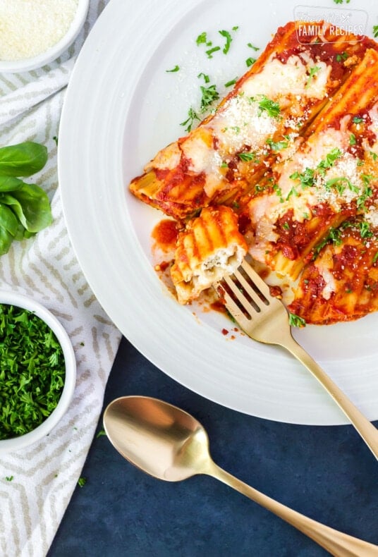 Fork stabbing a bite of cheese manicotti