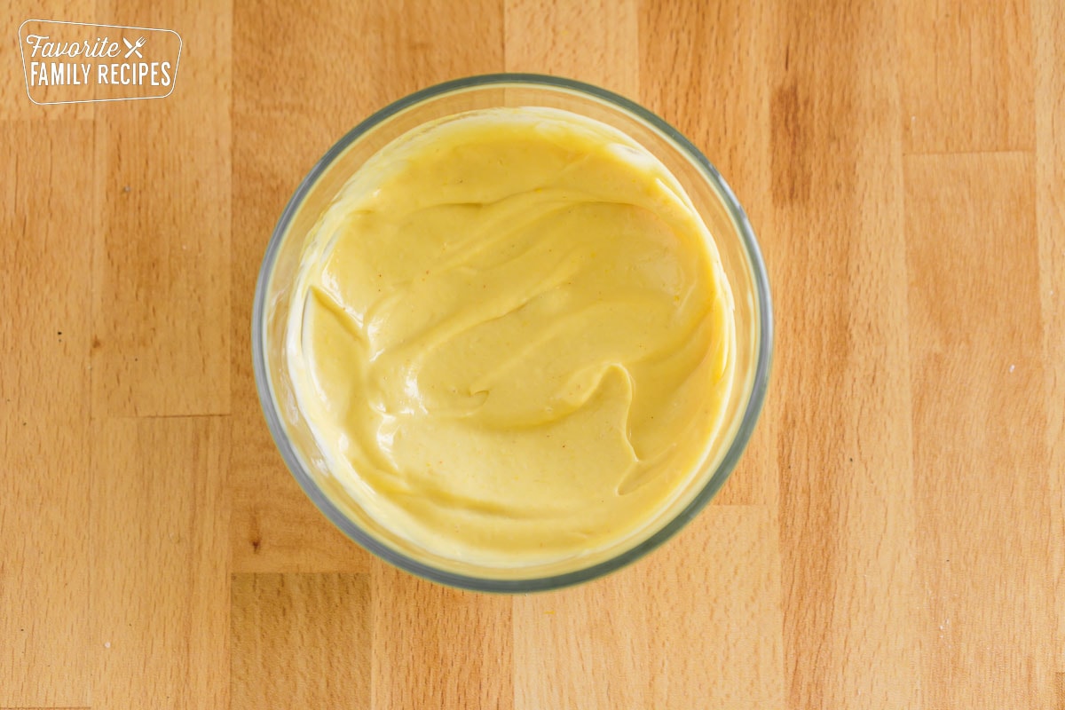 Mayonnaise and mustard combined in a small glass bowl