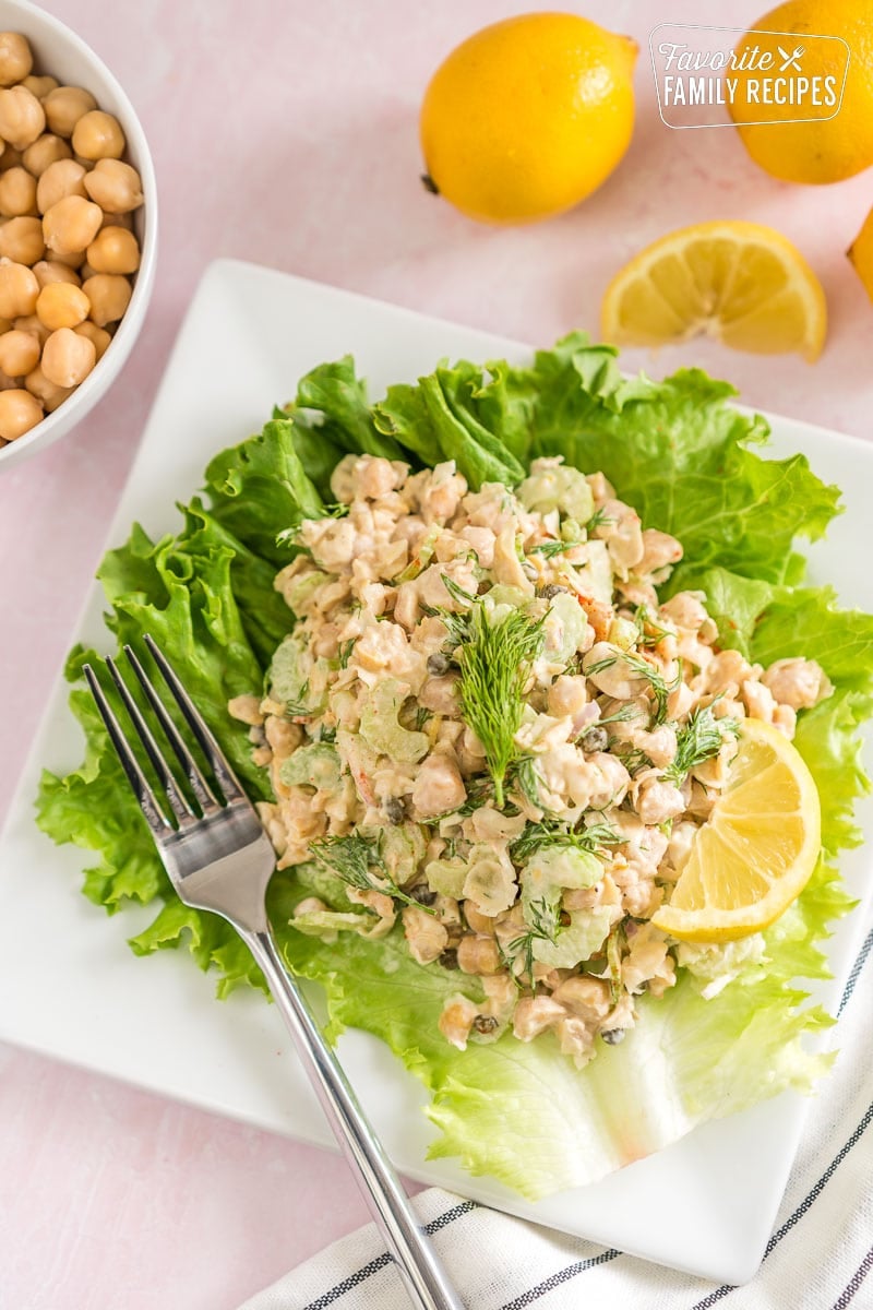 Check out this chickpea salad recipe for a fast, flavorful and healthy salad. Chickpeas are inexpensive and loaded with protein and fiber. Chickpea salad on a lettuce leaf topped with fresh dill.