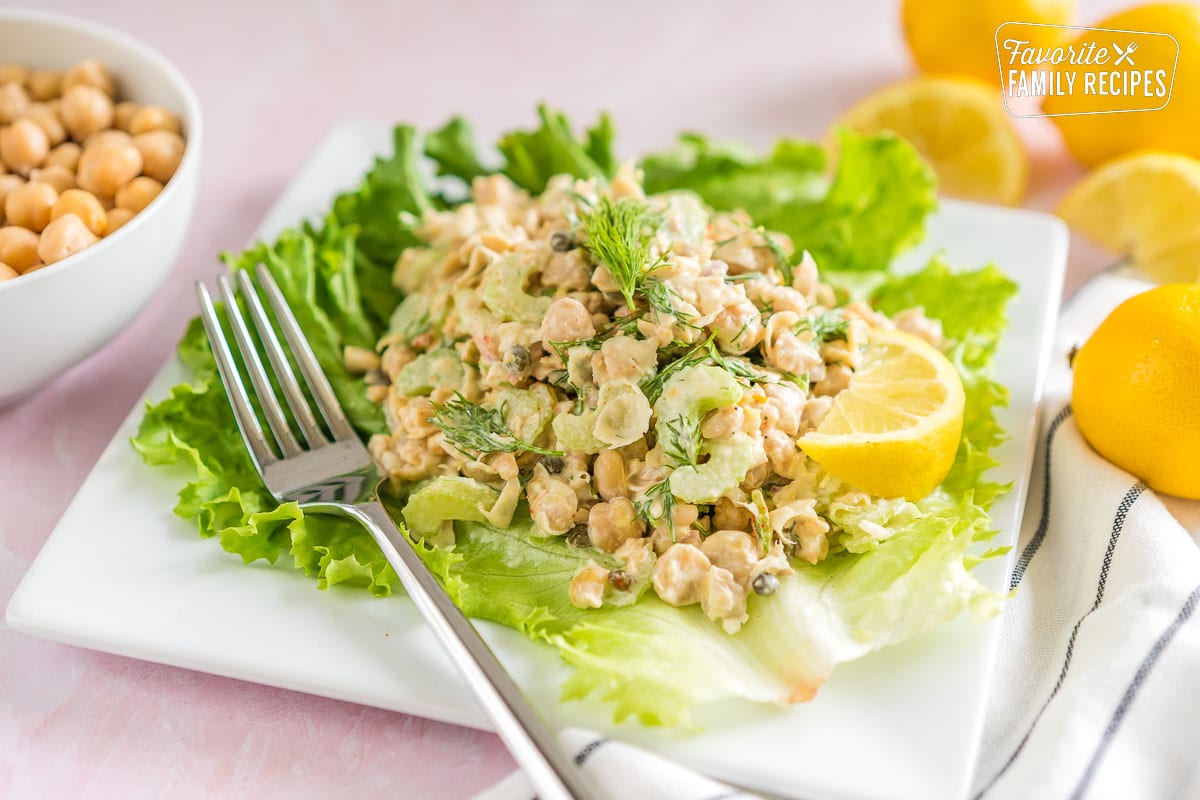 Check out this chickpea salad recipe for a fast, flavorful and healthy salad. Chickpeas are inexpensive and loaded with protein and fiber. Chickpea salad on a lettuce leaf topped with fresh dill.
