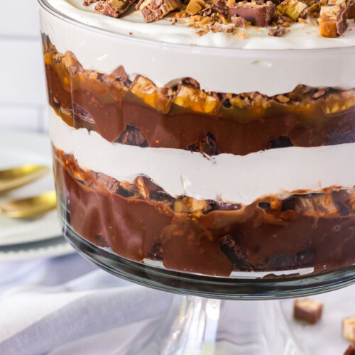 Chocolate trifle with layers of brownie, pudding, candy bars, caramel and whipped topping.
