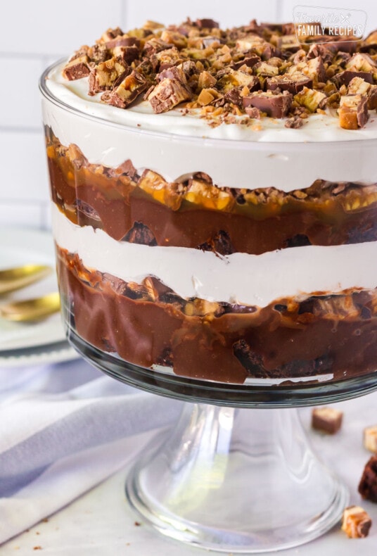 Chocolate trifle with layers of brownie, pudding, candy bars, caramel and whipped topping.