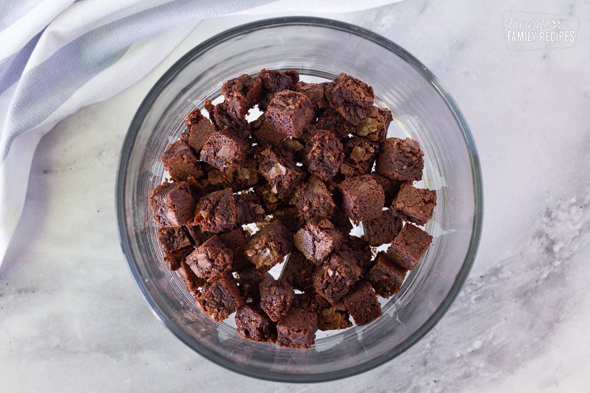 Glass Trifle bowl with chocolate brownie cubes for the bottom layer of the Chocolate Trifle.