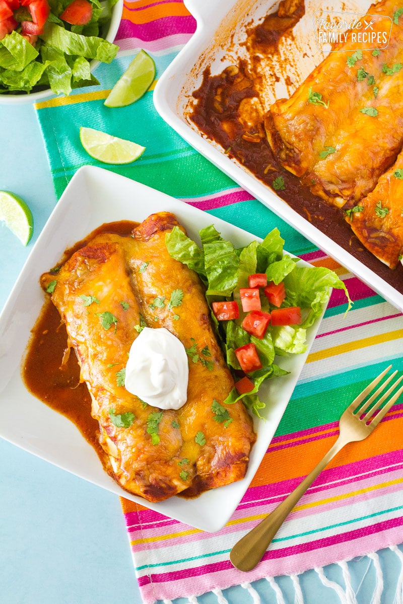 Two Enchiladas with Homemade Enchilada Sauce topped with sour cream.