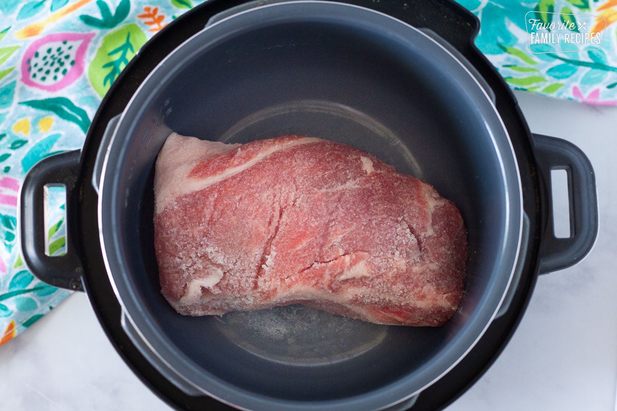 Raw pork Roast in a slow cooker.