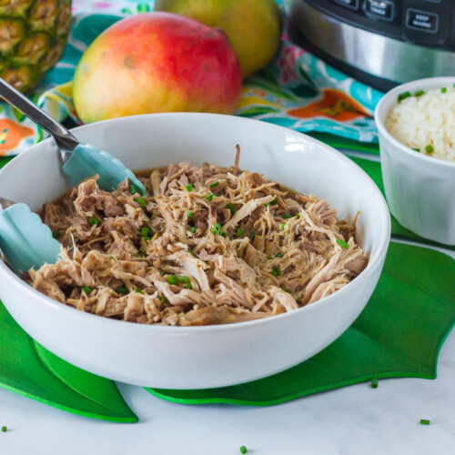 Kalua Pork in a serving dish with tongs.