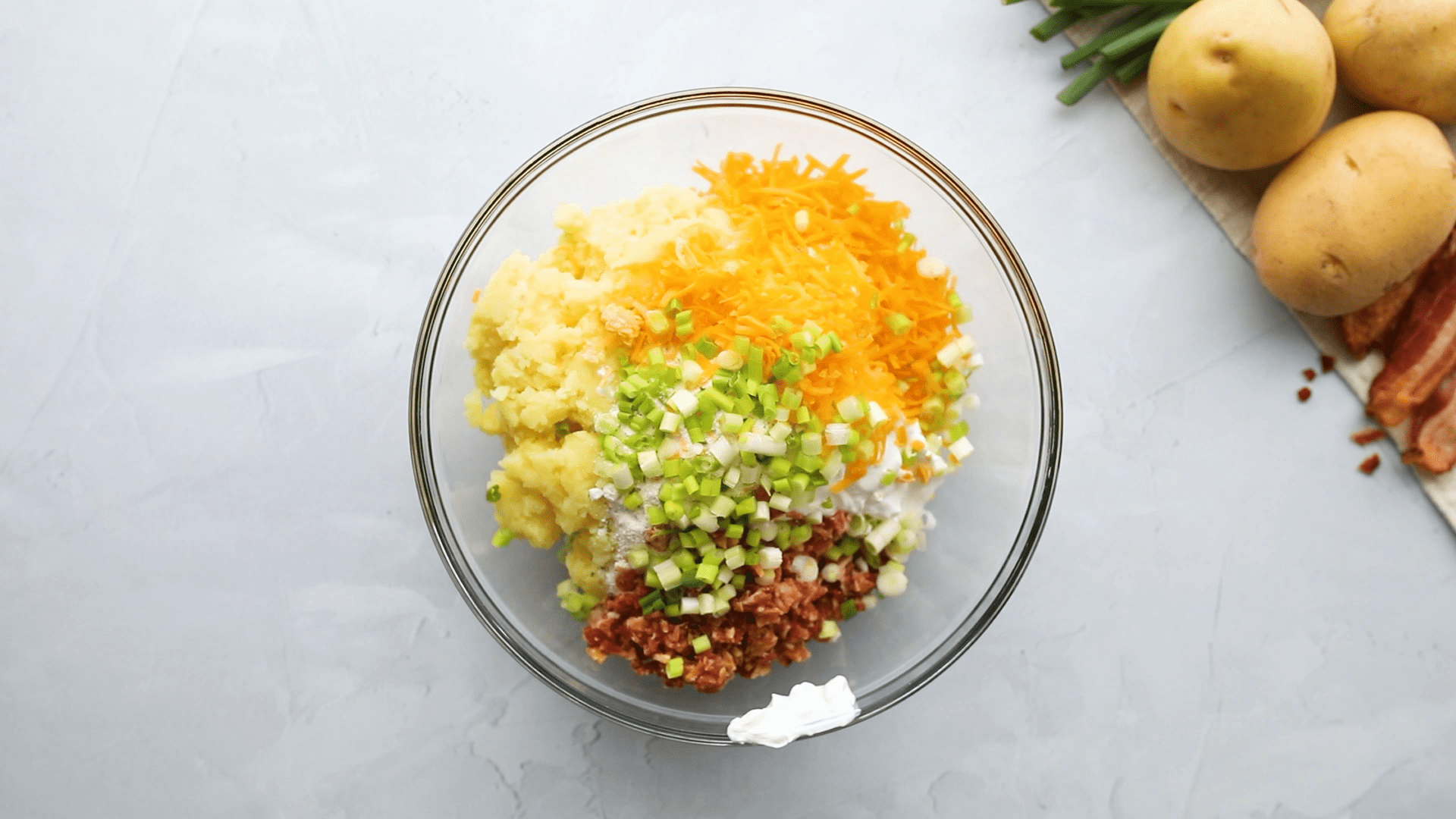 A bowl filled with Loaded Mashed Potatoes ingredients