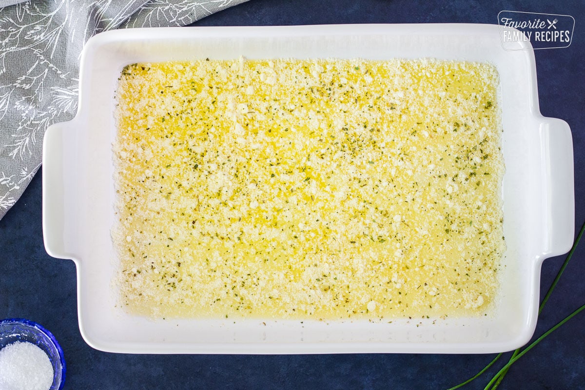 9x13 dish with melted butter, parmesan cheese and herbs.