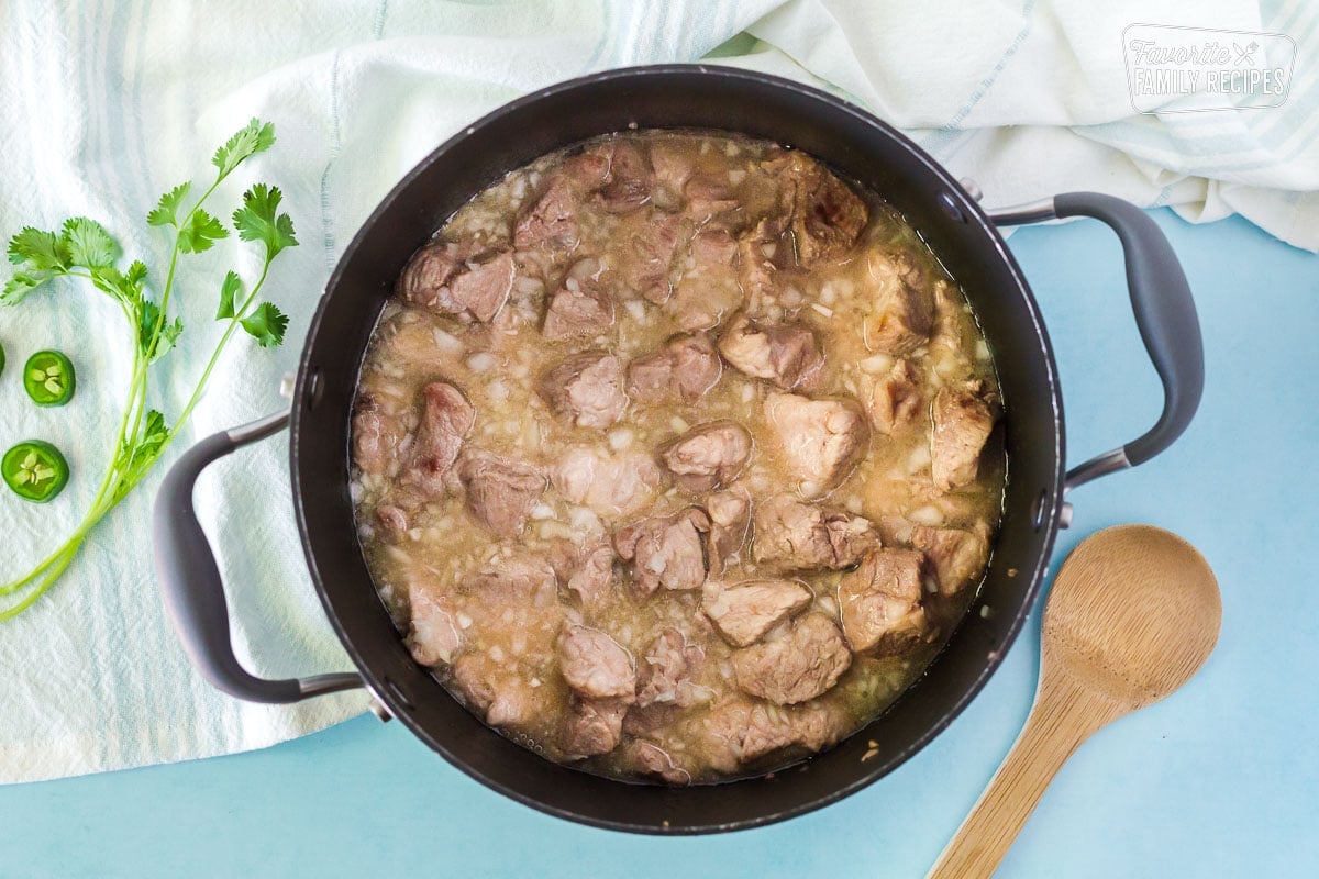 Large pot with chicken broth and onion to simmer for Pork Chili Verde.