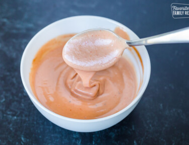 A spoon dipping into a bowl of campfire sauce