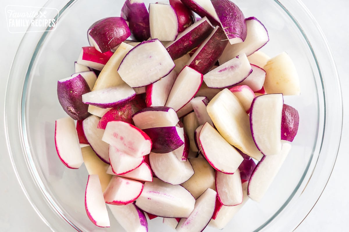 Chopped rainbow radishes in a glass bowl.