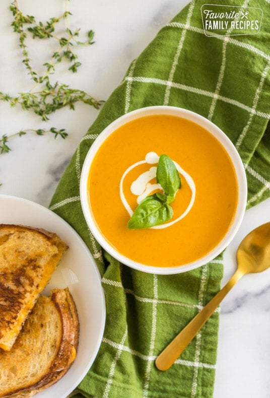 Roasted Tomato Soup in a bowl topped with cream and a basil leaf