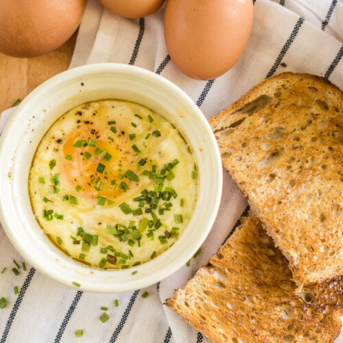 Shirred Eggs in a ramekin with toast next to it