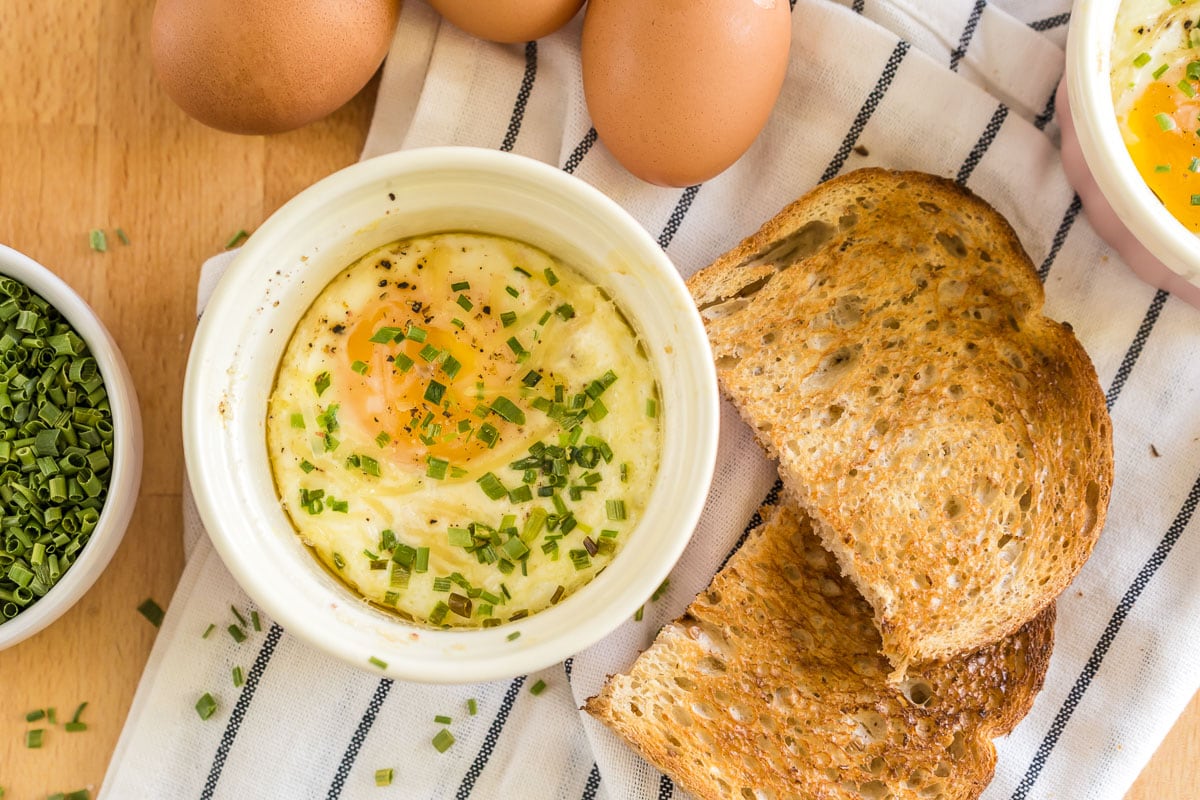 Shirred Eggs in a ramekin with toast next to it