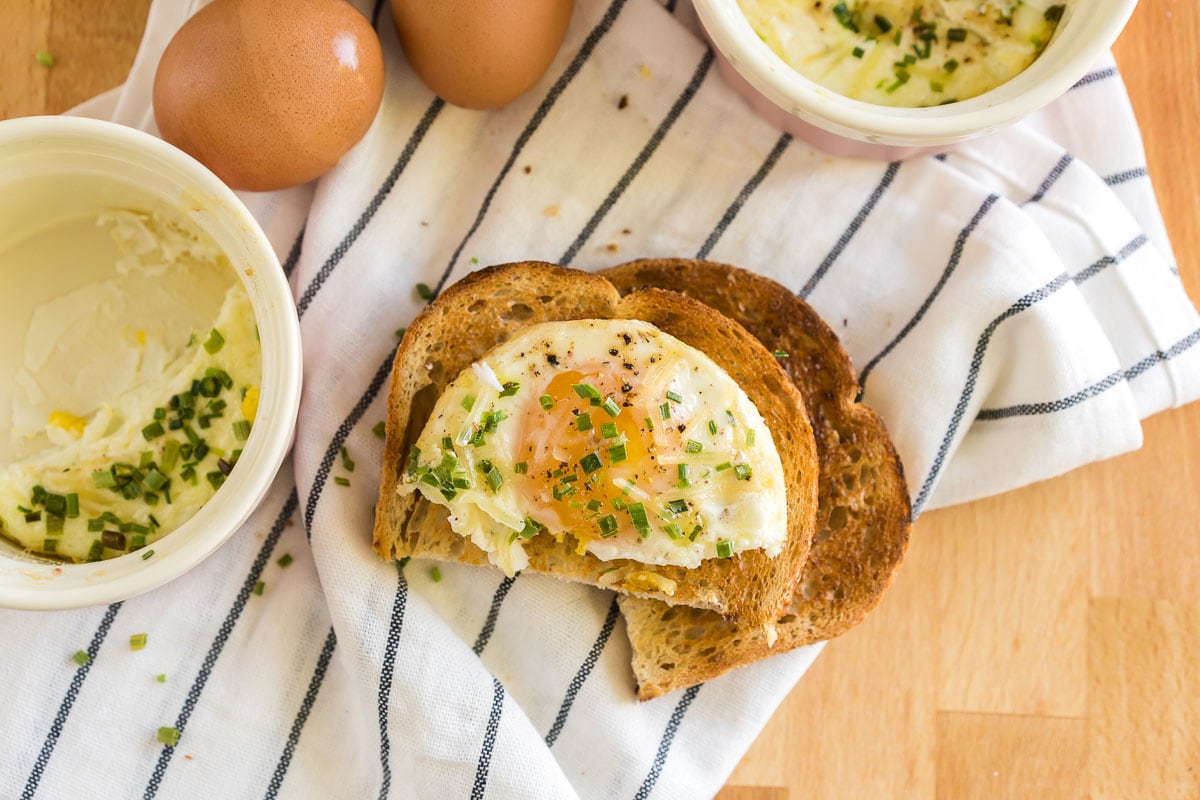 A shirred egg scooped out of a ramekin and placed on toast