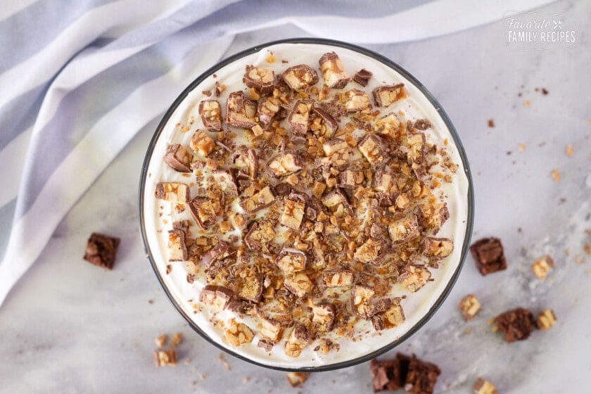 Cut up Snickers and crushed Heath bars on the topping of the Chocolate Trifle. Brownies and snickers sprinkled on the table around the dish.