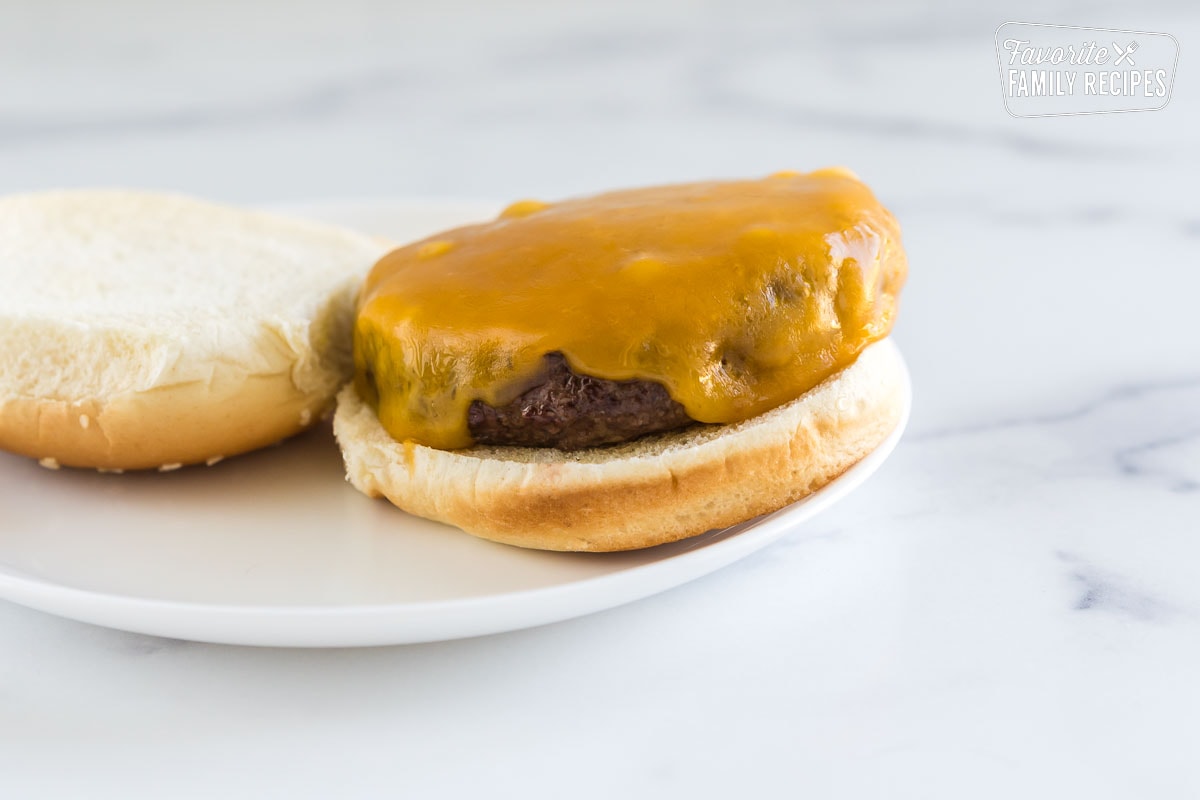 A hamburger patty with melted cheese on a bun