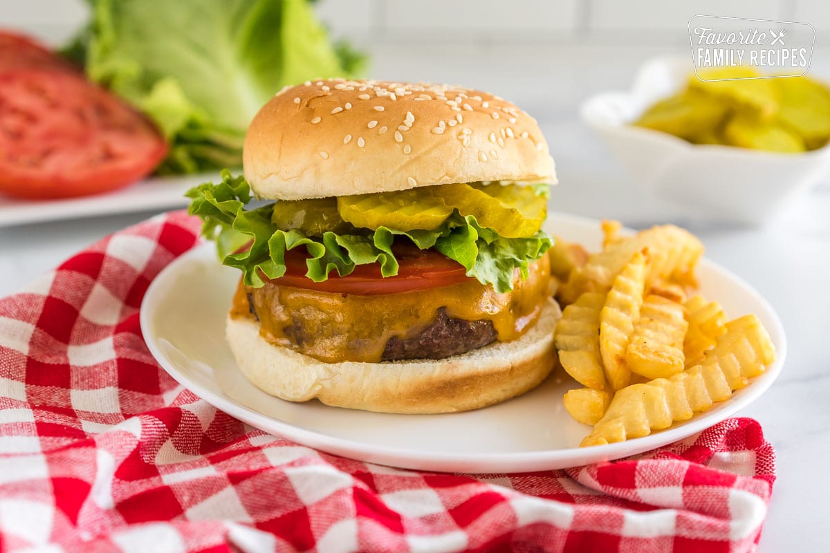 An air fryer hamburger on a plate with fries