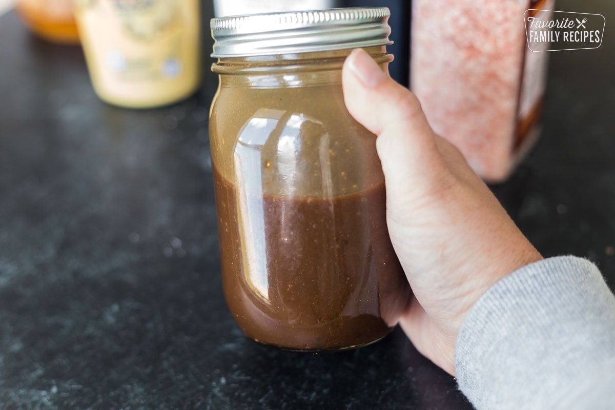 A jar of balsamic vinaigrette being shaken.